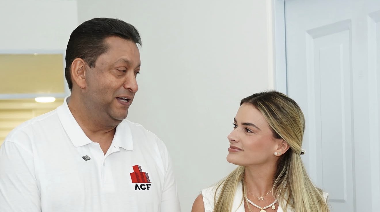 Un directivo de ACF explica a la primera dama los detalles de la casa modelo.