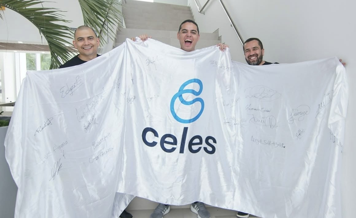 Integrantes de Celes con la bandera firmada por el equipo durante el Celes Summit 2025, en Barranquilla.
